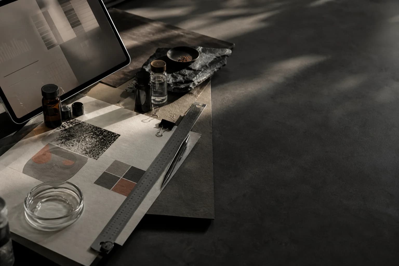 Graphite research desk with beauty formulation samples, source materials and abstract market data