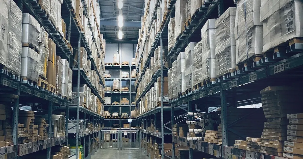 Realistic warehouse aisle with stocked shelves and cool industrial lighting, uniquely composed for Target, APRIL, and Uber Point to a...