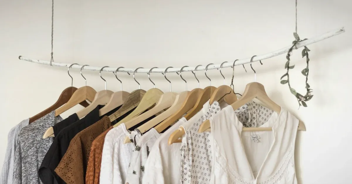 Realistic neutral fashion rack with tailored garments in a quiet retail studio, uniquely composed for Vogue, LA Auto Show, and...